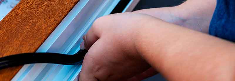 Man Sealing Door with Rubber Stripping