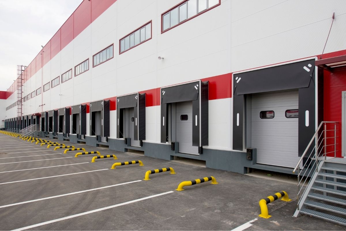 Sectional door system operating in a high-traffic warehouse bay