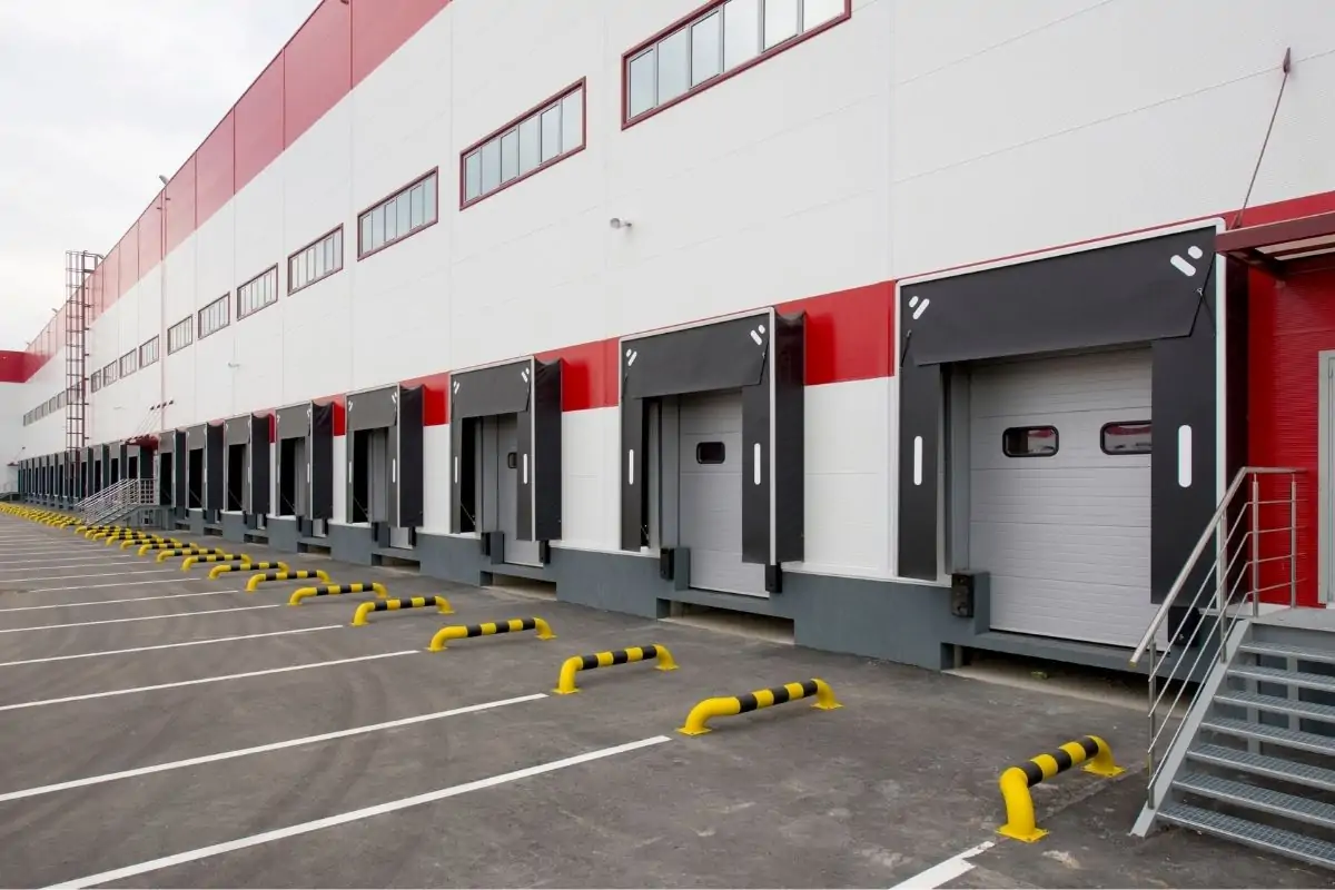 Sectional door system operating in a high-traffic warehouse bay